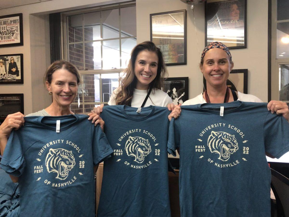 Angie Howard, Grace Ann Lukach '03, and Amanda Payne hold up the freshly designed Fall Fest t-shirts.