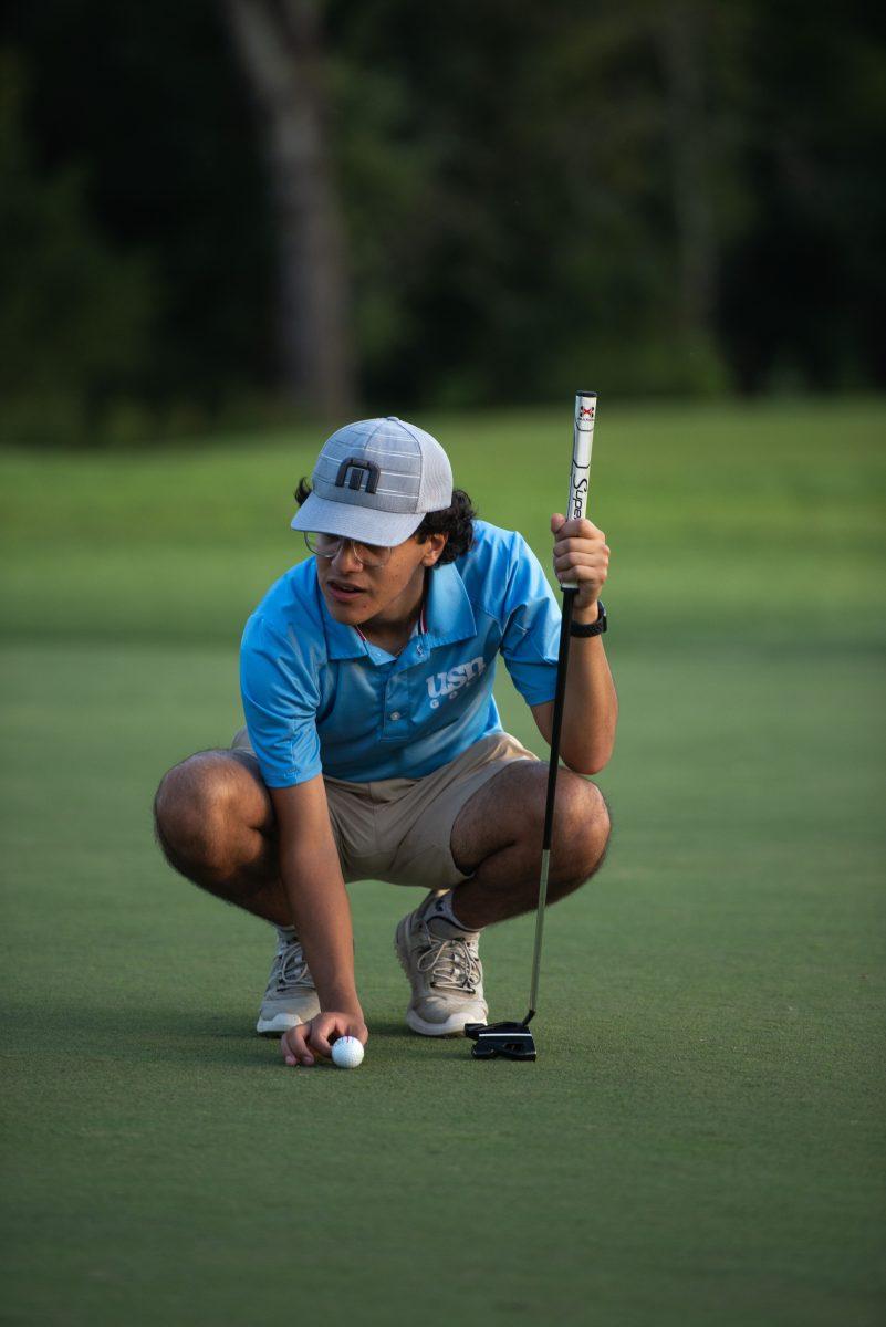 Omeed Irani '26 lines up his putt (via Nicholas Woodard '24)