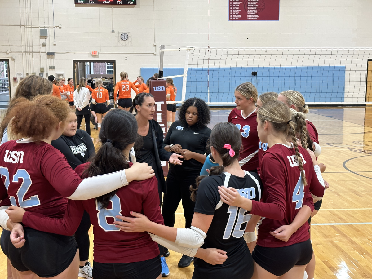 The Tigers huddle between sets (via the Peabody Press)