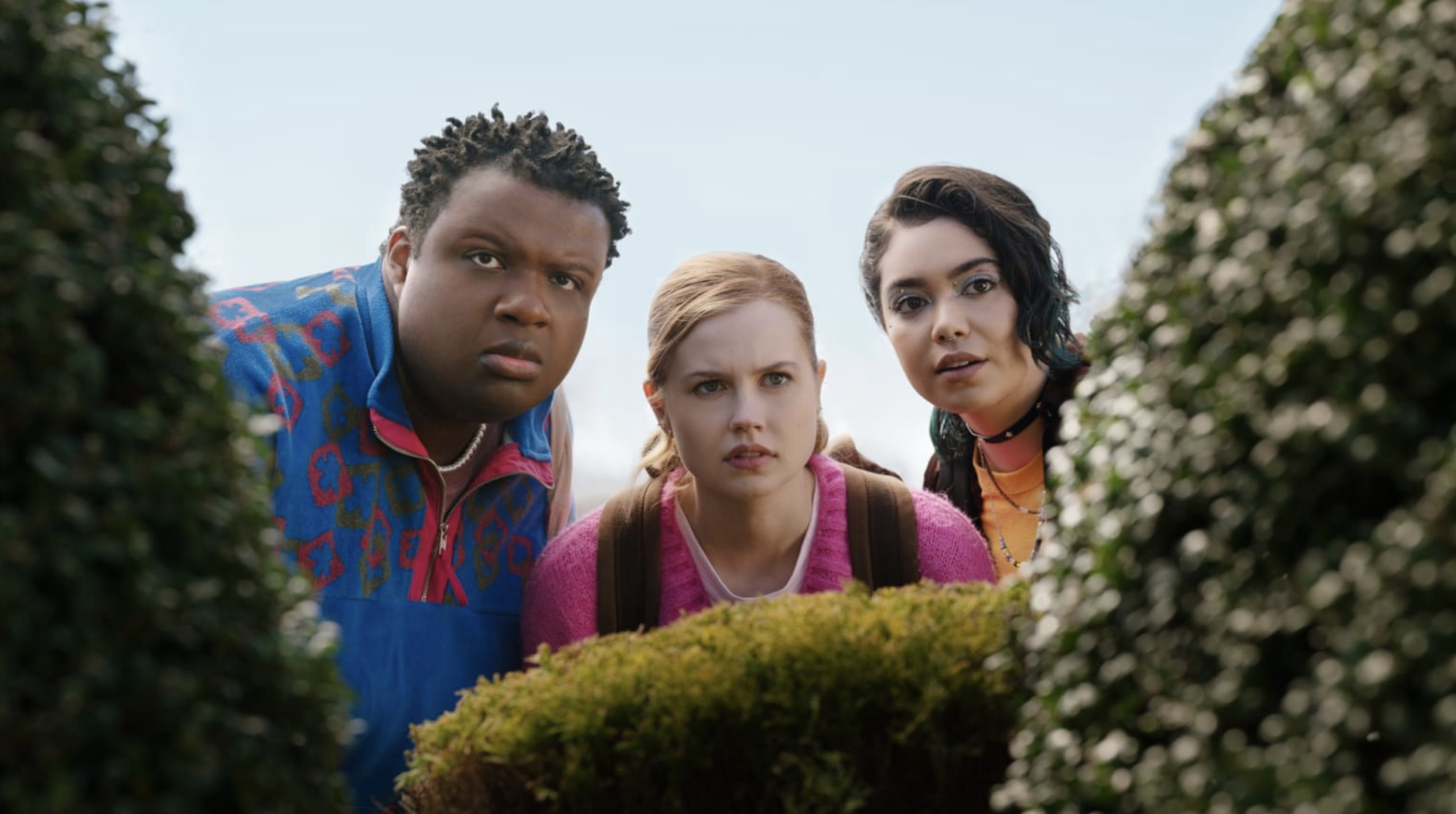 Damien, Cady, and Janice peeking through the bushes at their school (via the Daily Beast).