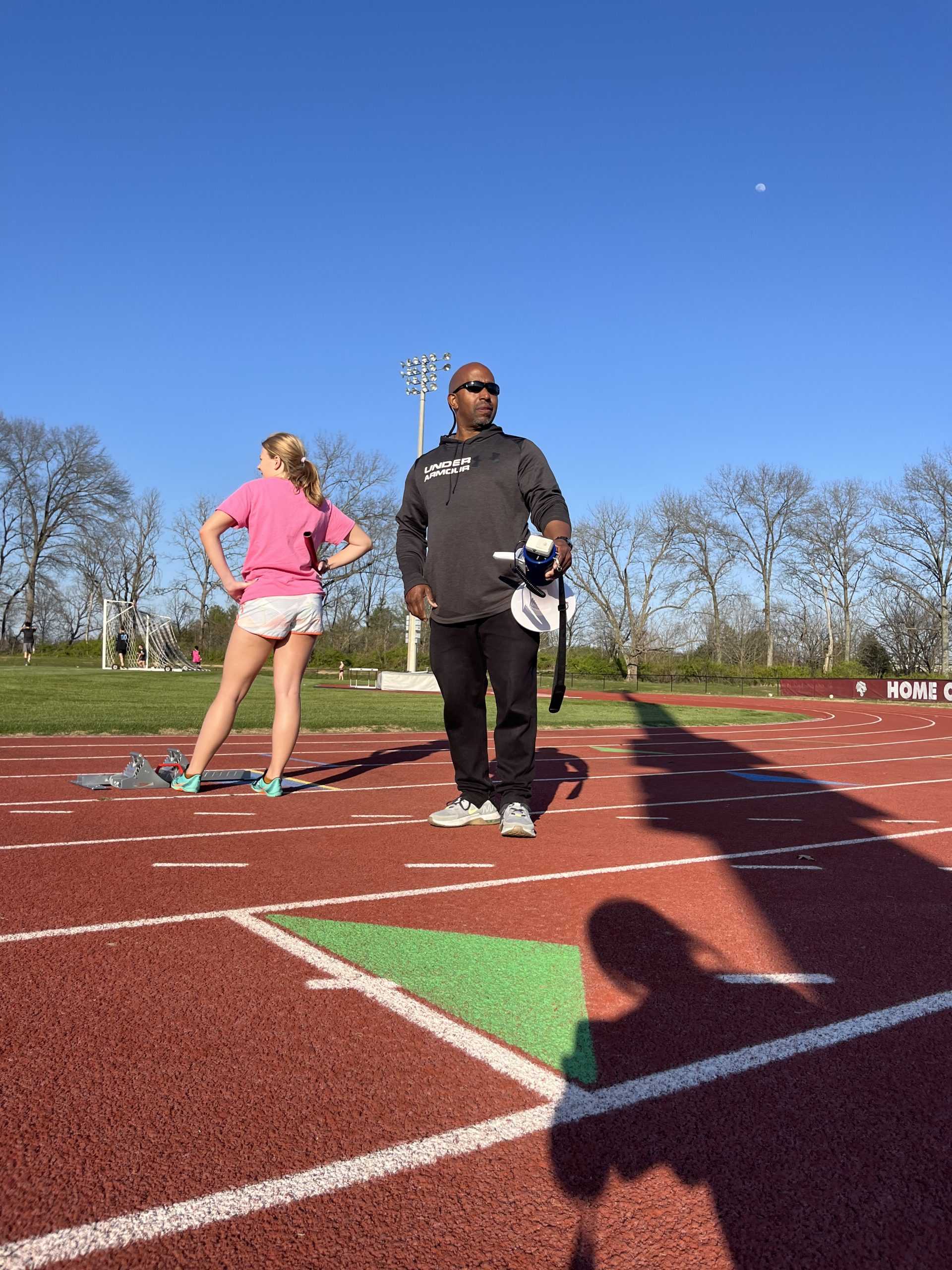 Coach Hill at a track practice with megaphone in hand (via the Peabody Press).