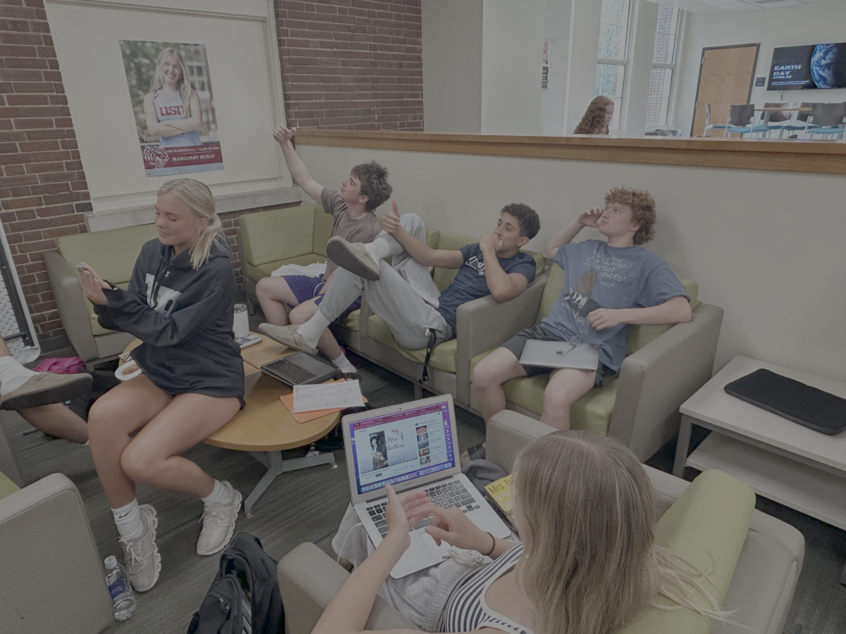 Below: Seniors in the library lobby adapt to life without phones, but old habits are hard to change. (via the Peabody Press)