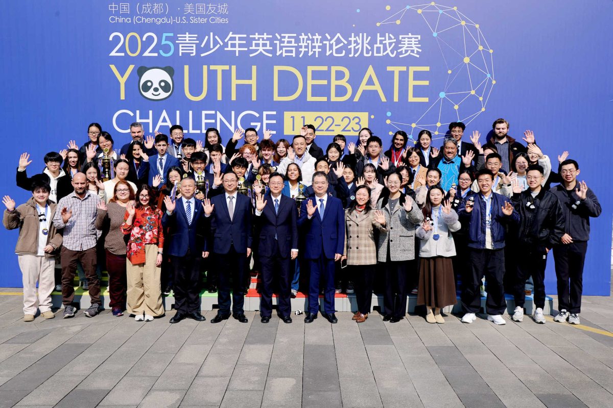 Students and chaperones from across the world wave to the camera. 
