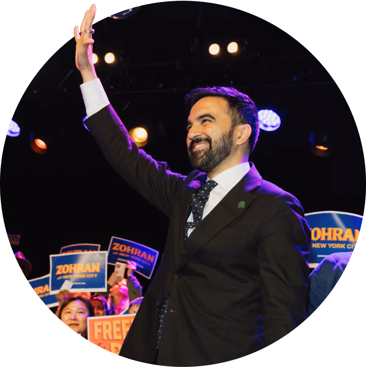 Mamdani waves to the crowd at a campaign event. (via transition2025.com)
